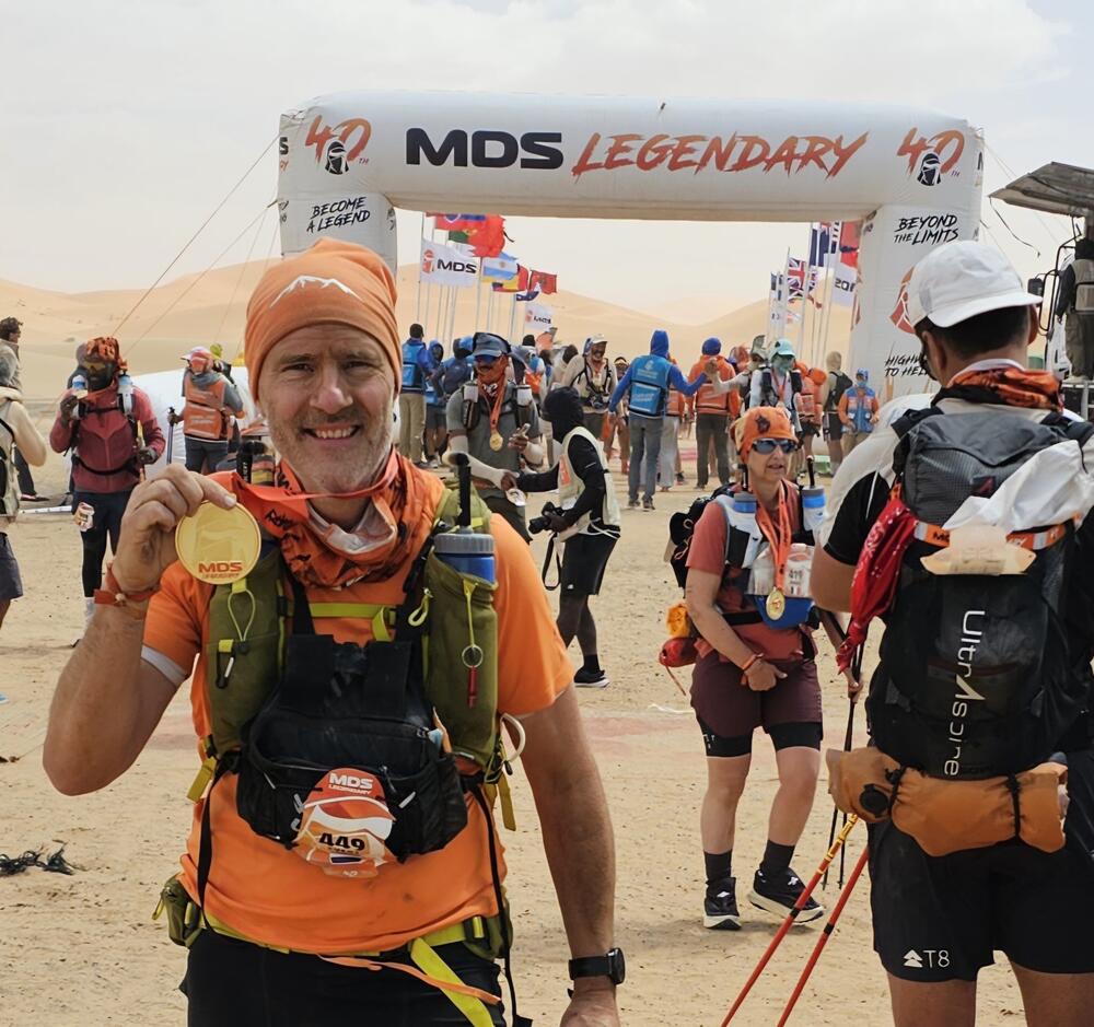 Evert met zijn finishersmedaille onder de finishboog van de Marathon des Sables Legendary